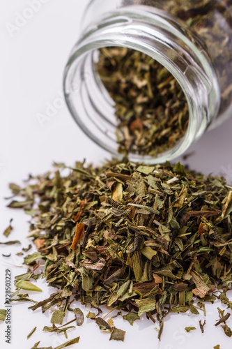 dried tarragon and essential oil on a white background