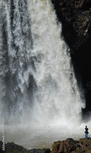 Woman standing by waterfall, Bahir Dar, Ethiopia