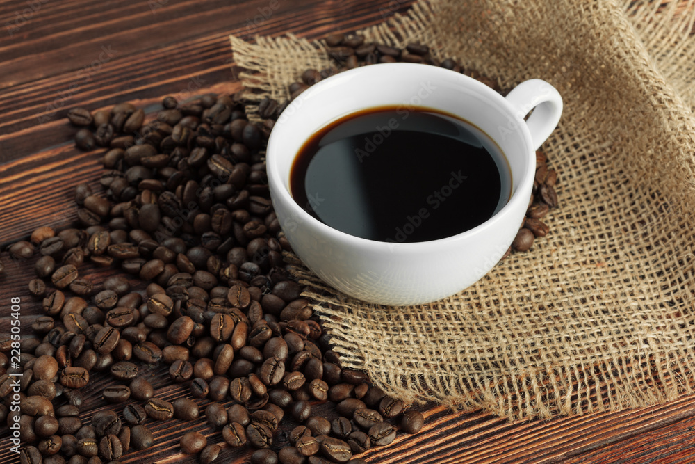 Coffee cup and coffee beans on wooden background Coffee cup and coffee beans on wooden background