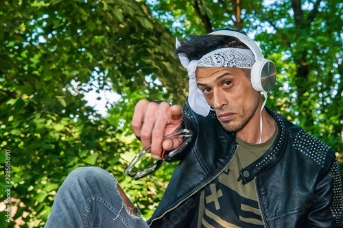 Foto Extravagant (hipster) male model listen to music in nature