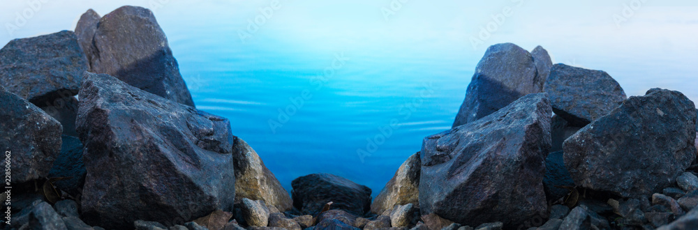 Stones by the river, water, sea background.