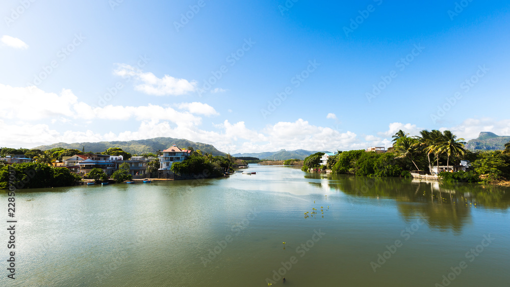River scene with mountains in Mahebourg, Mauritius. Mauritius, an Indian Ocean island nation, is known for its beaches, lagoons and reefs. River scene with mountains in Mahebourg, Mauritius. Mauritius, an Indian Ocean island nation, is known for its beaches, lagoons and reefs.