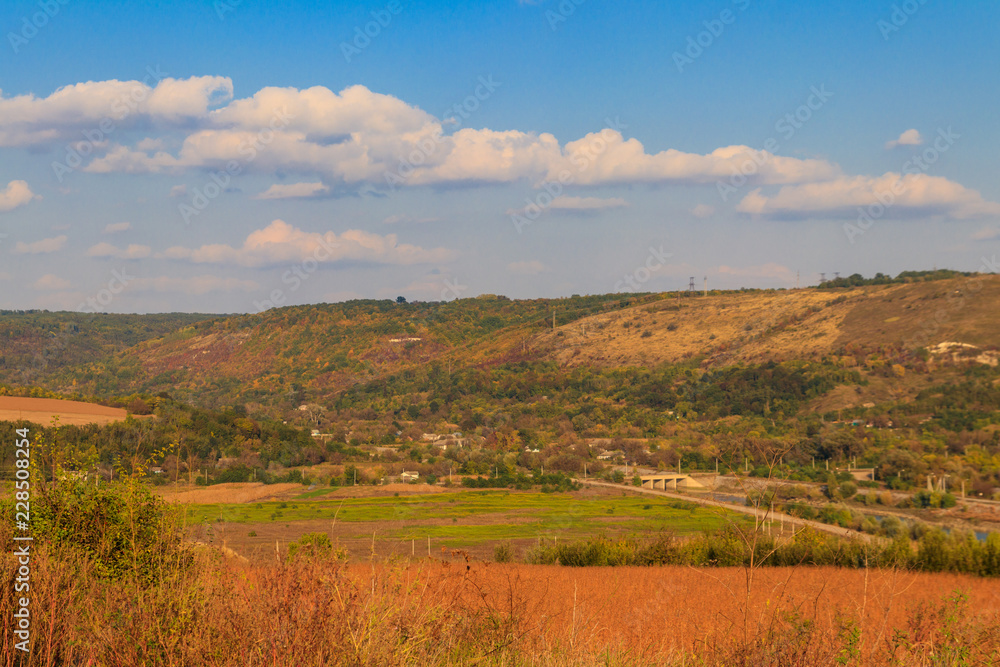 Picturesque autumn scenery with blue sky and colorful autumn trees on mountain hills