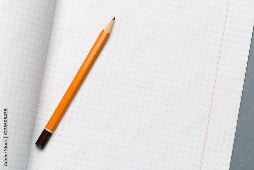 Pencils and notepad paper sheets on gray desk table Pencils and notepad paper sheets on gray desk table