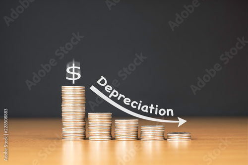 STACKED US QUARTER COINS ON WOODEN TABLE WITH WHITE ILLUSTRATION SHOWS DEPRECIATION IN US DOLLAR VALUE / FINANCIAL CONCEPT photo