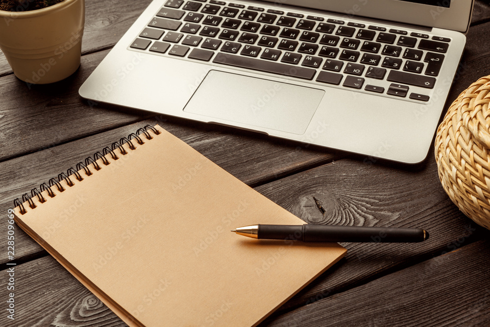 Office table with blank notebook and laptop / Coffee cup Office table with blank notebook and laptop / Coffee cup