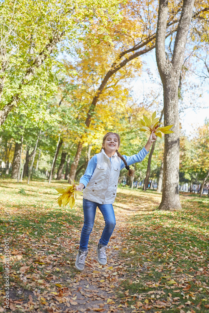 Beautiful happy girl in autumn park.