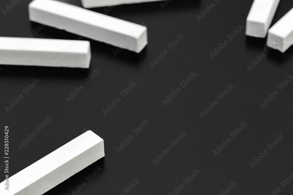 pieces of white chalk photographed over a blackboard pieces of white chalk photographed over a blackboard