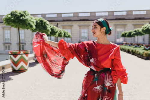 Young spanish woman in a red blouse and green pants. Fashion latin look. Flamenco woman smiling photo