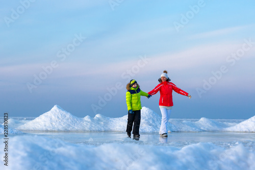 Young mother and her son on icy beach