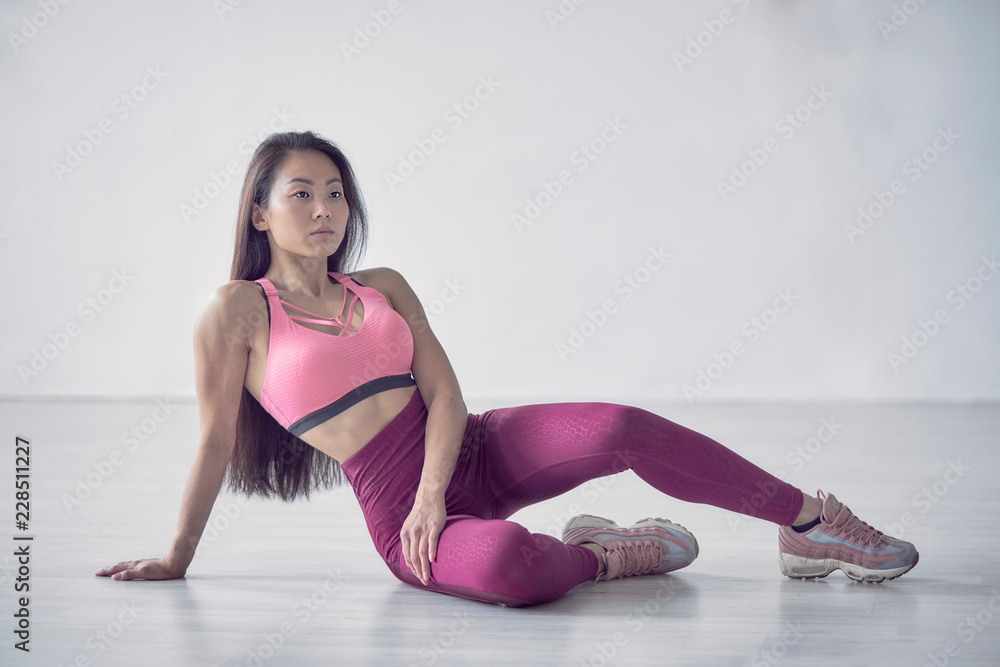 Stockfoto Be motivated! Beautiful sexy fitness woman posing full lengthd.  middle eastern female sports clothing relaxing after workout grey background.  Muscular female body. Image with copyspace