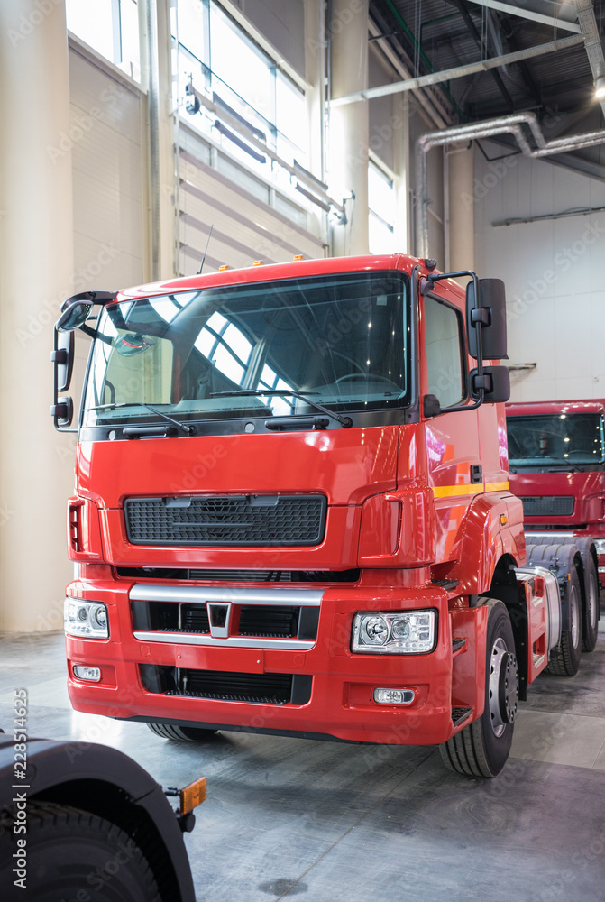 Red commercial truck parked in manufacture building
