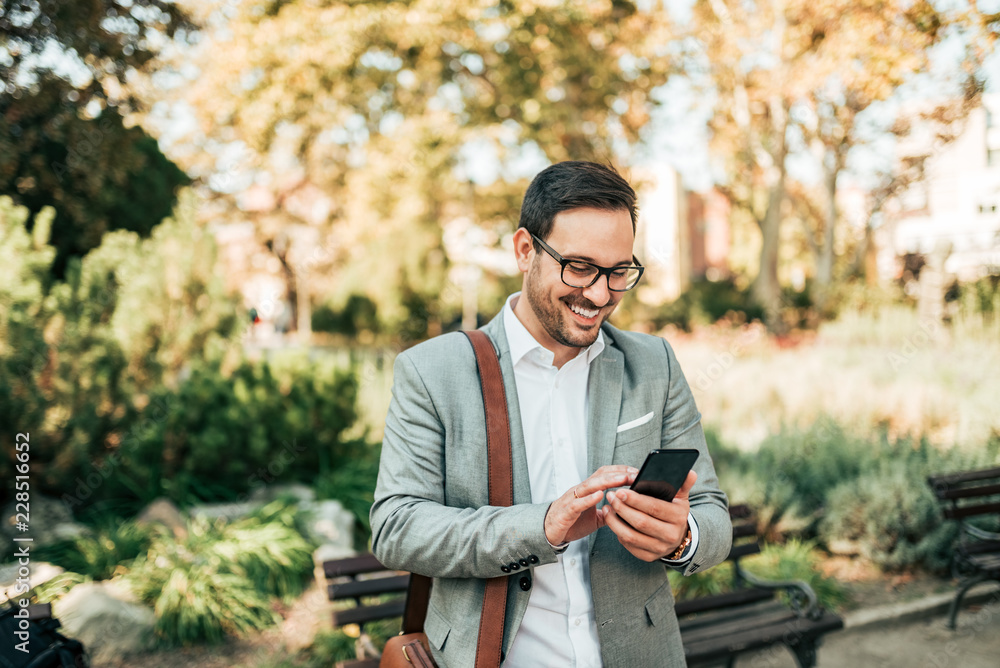 Happy elegant man using smartphone outdoors. Happy elegant man using smartphone outdoors.