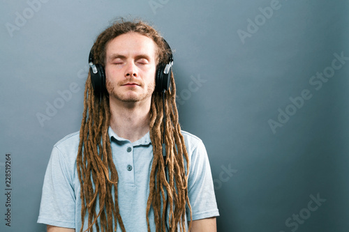 Man listening to headphones on a solid background