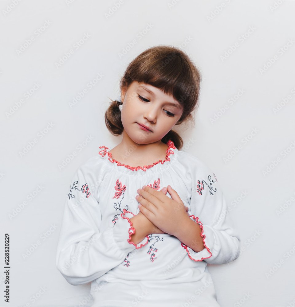 Devoted Ukrainian patriots. Heroes of War. Little Ukrainian Girl Patriot holds her hand on the heart. Peace concept. Copy space. Poster. Devoted Ukrainian patriots. Heroes of War. Little Ukrainian Girl Patriot holds her hand on the heart. Peace concept. Copy space. Poster.