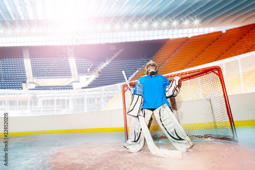 Photography Young goalie guarding his net during hockey game
