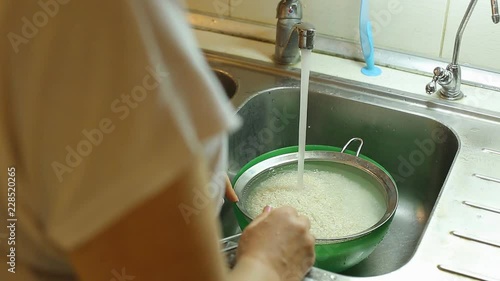 housewife washes rice in the kitchen for cooking pilaf at home