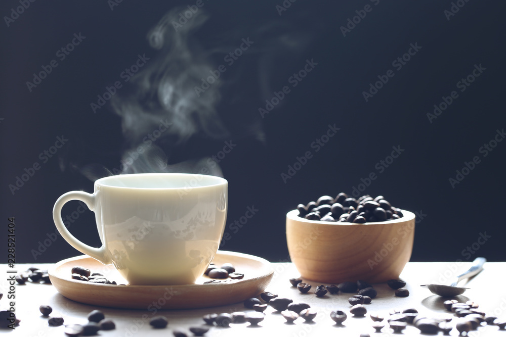 Fototapeta premium Selective focus of Coffee cup and beans with smoke rising on dark background