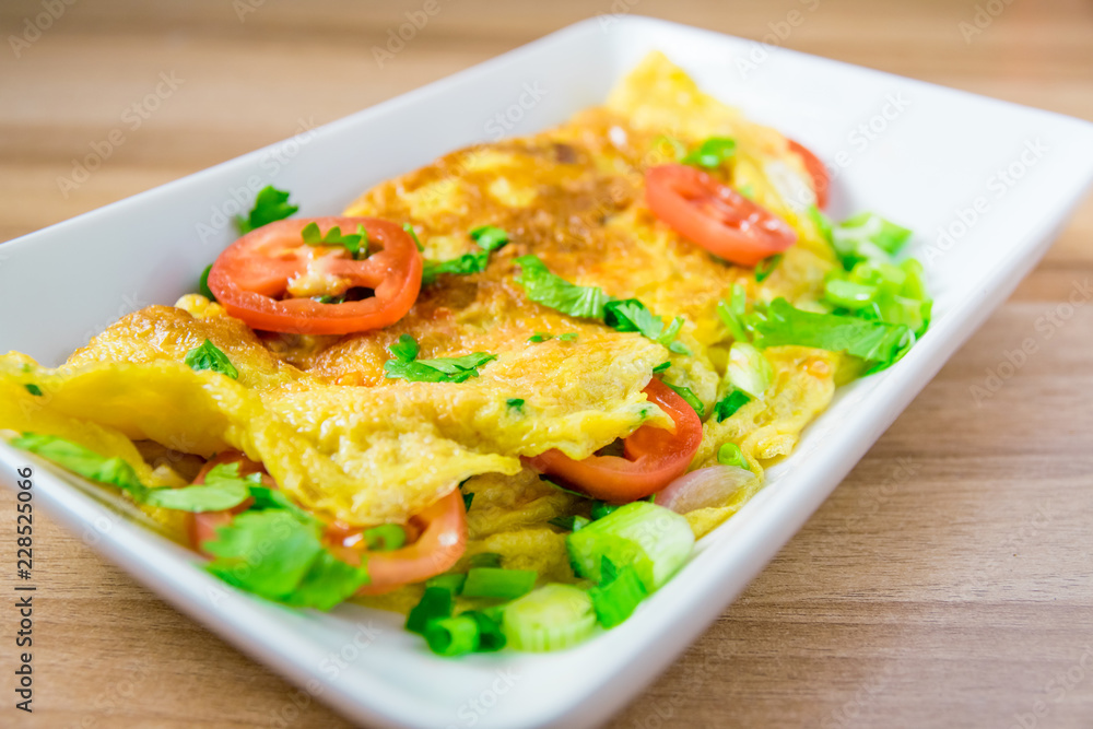 A photo of an omelette with cherry tomatoes, parsley. and grated cheese, shot from above on a rustic wooden texture with a place for text A photo of an omelette with cherry tomatoes, parsley. and grated cheese, shot from above on a rustic wooden texture with a place for text