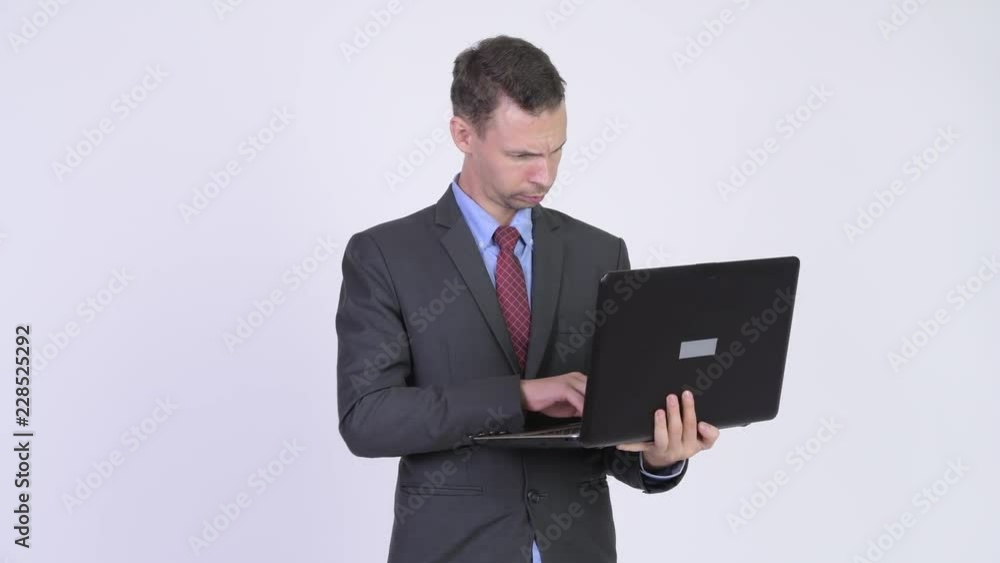 Studio shot of happy businessman using laptop Studio shot of happy businessman using laptop