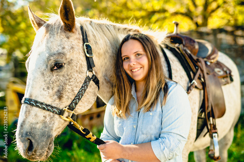 A Beautiful teen girl on the farm with her horse.
