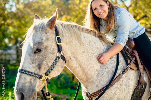 A Beautiful teen girl on the farm with her horse.