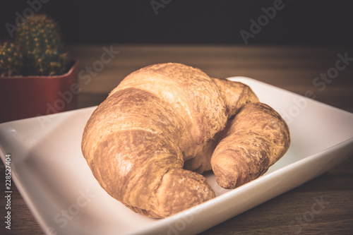 Tasty buttery croissants on old wooden table.