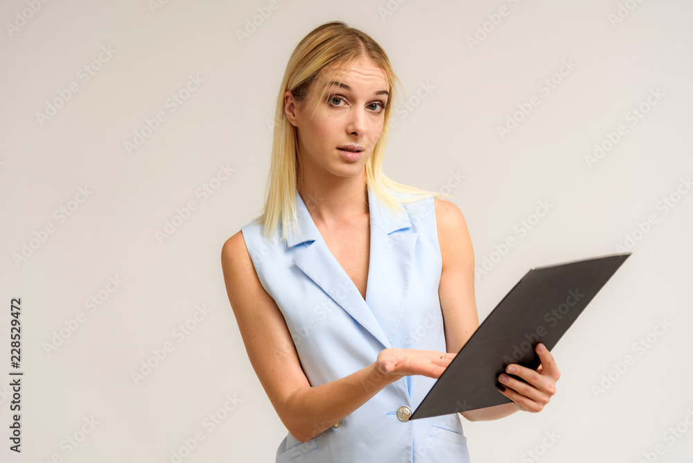 Studio photo of a beautiful blonde girl talking in a business suit on a white background. Studio photo of a beautiful blonde girl talking in a business suit on a white background.