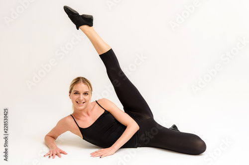 Studio photo of a beautiful blonde girl doing fitness stretching exercises on a white background. photo