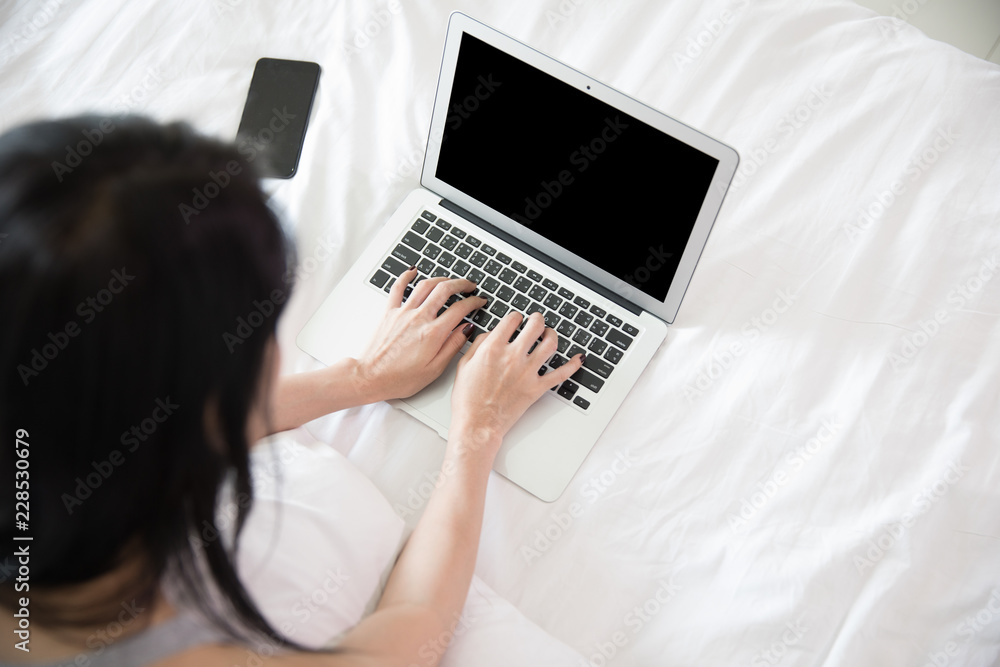 woman and laptop in bedroom on white bed woman and laptop in bedroom on white bed