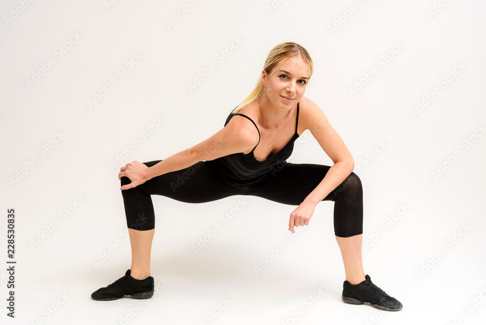 Studio photo of a beautiful blonde girl doing fitness stretching exercises on a white background. Studio photo of a beautiful blonde girl doing fitness stretching exercises on a white background.