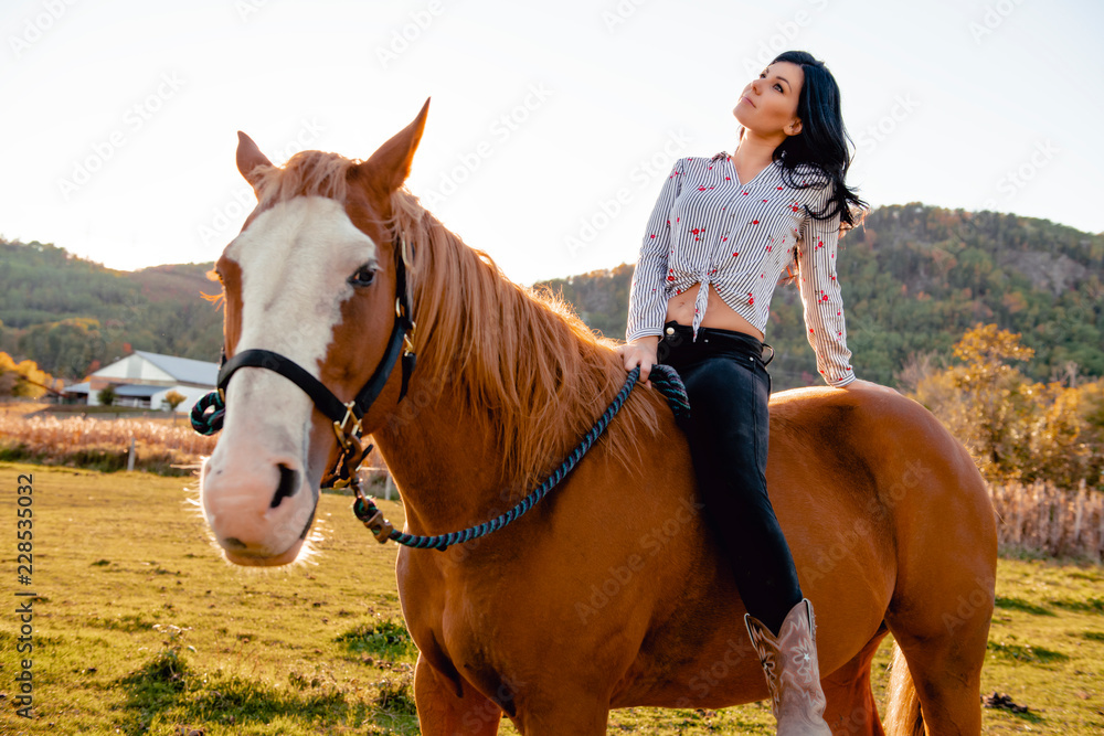 A Woman with her horse at sunset, autumn outdoors scene A Woman with her horse at sunset, autumn outdoors scene