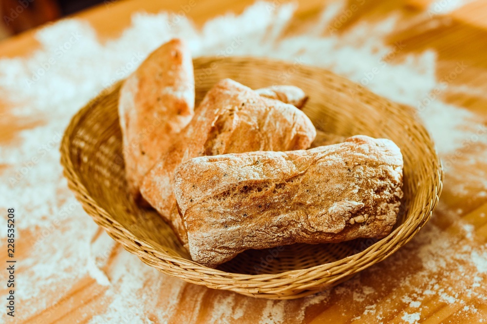 bread in a basket on a table covered in flour