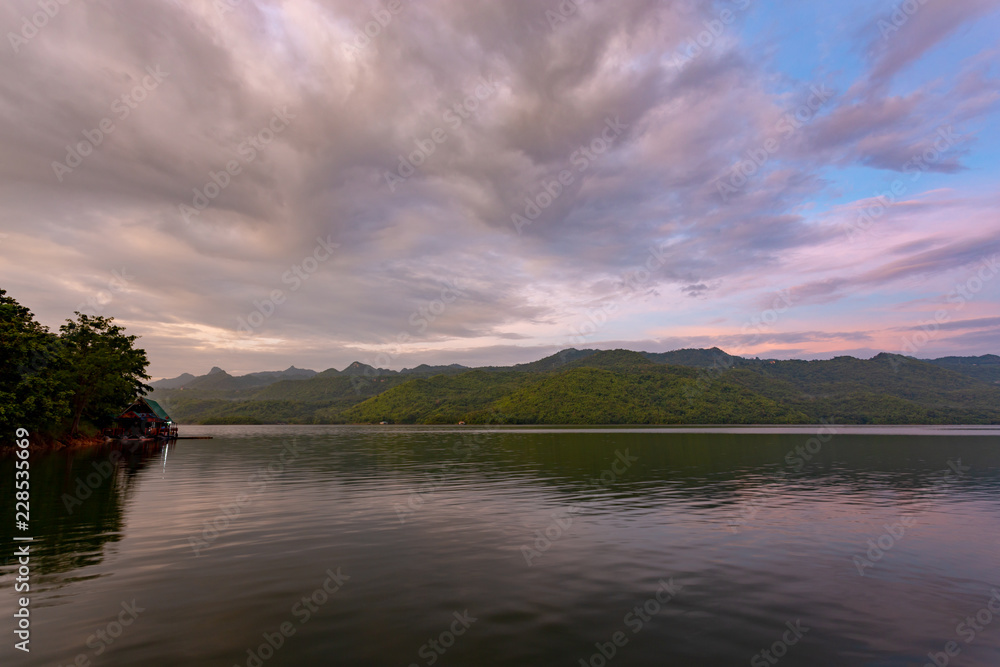 Landscape of the mountain and The ship is on the river with blue sky in the morning. View of the mountain with blue sky at Srinakarin Dam , Kanchanaburi province , Thailand.