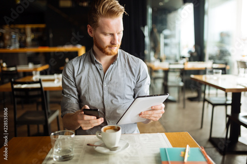 Handsome smart businessman constantly busy and working