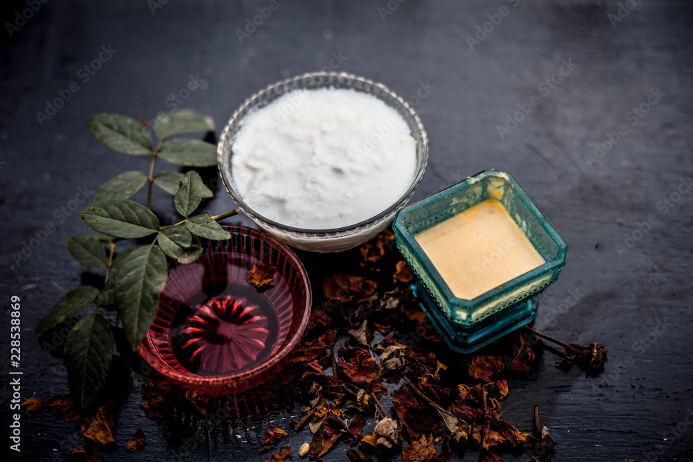 Close up of herbal and ayruvedic face  pack of rose or Rosa or Rosaceae or gulab with its extracted rose water in a glass bowl with gram flour and yogurt on wooden surface,Top shot view.