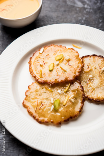 Malpua sweet - Traditional Indian dessert or pancake for festivals, served in plate with rabri/rabdi . selective focus