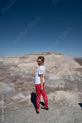 Fit attractive active woman stands and enjoys the view at the Blue Mesa trail in Petrified Forest National Park Arizona