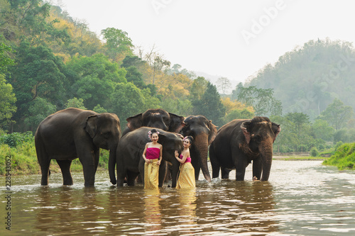 Beautiful Asian Woman wears thai dress with her elephant
