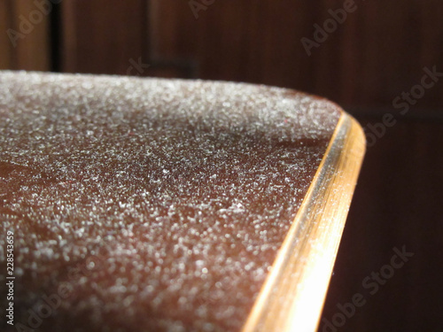 Close up of dust on wooden table . Dusty surface