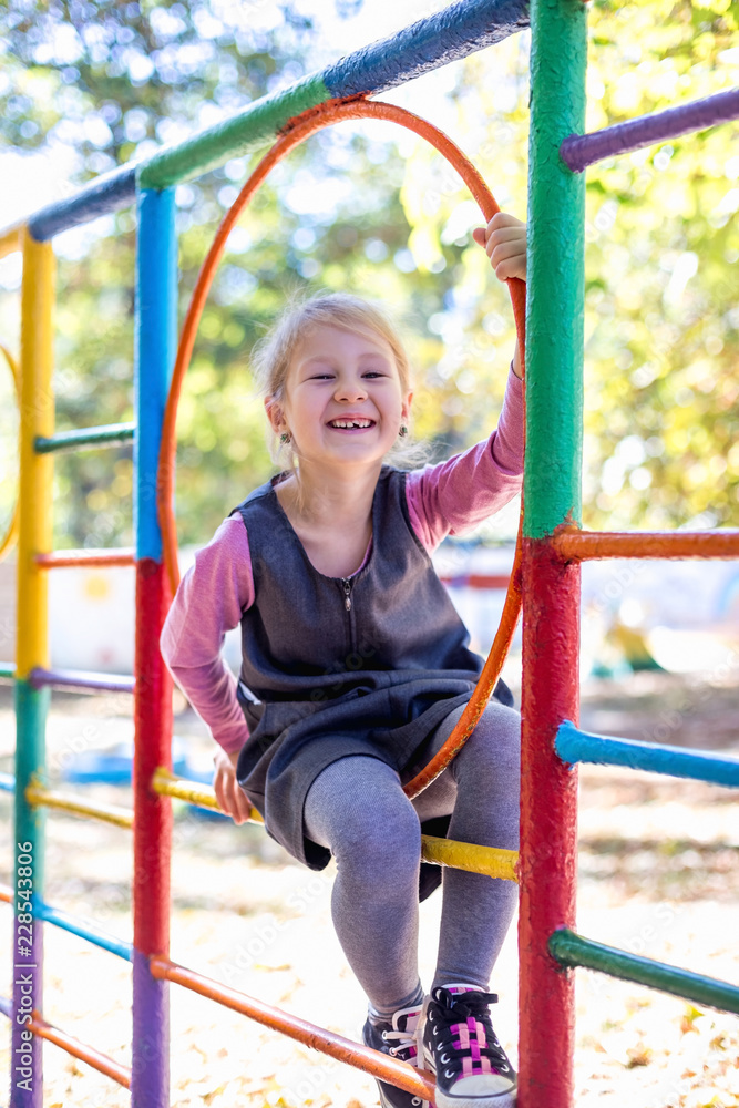 Fototapeta premium Little cute girl on the playground in the summer