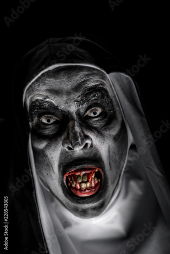Fotografía frightening evil nun with bloody teeth.