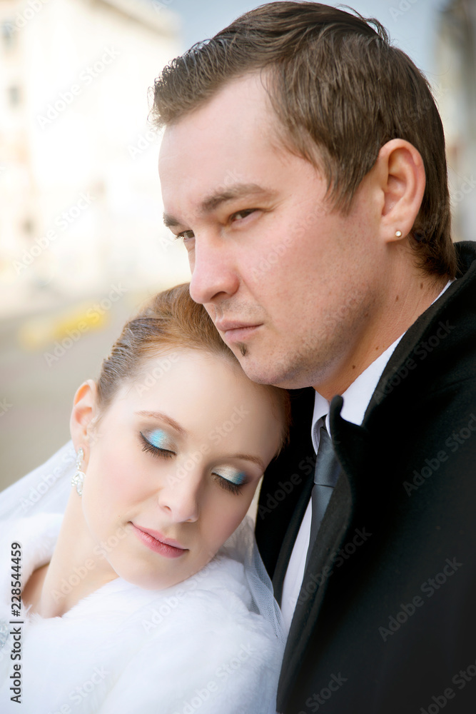 Wedding portrait of stylish bride and groom on a city street on an autumn day close-up. Wedding portrait of stylish bride and groom on a city street on an autumn day close-up.