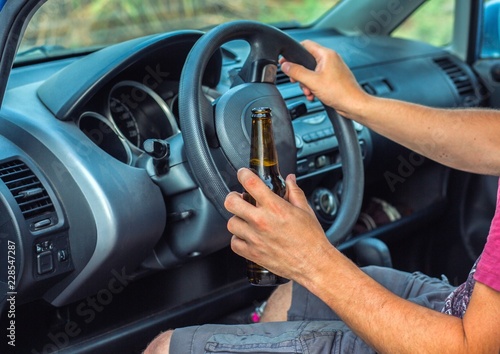 Man drinking alcohol while driving a car © layue