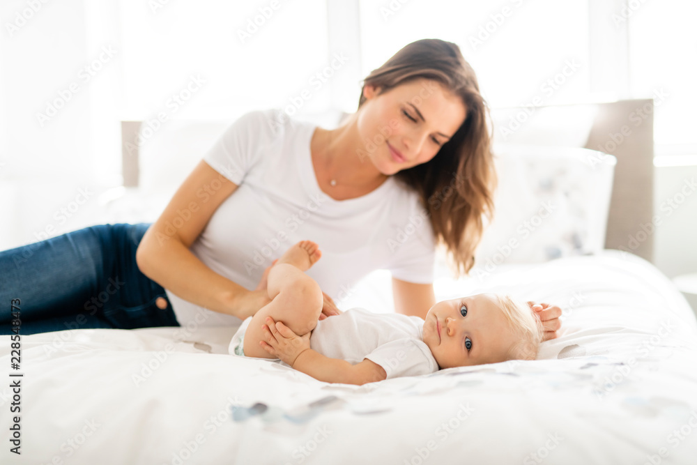 mother with baby on bed having good time mother with baby on bed having good time