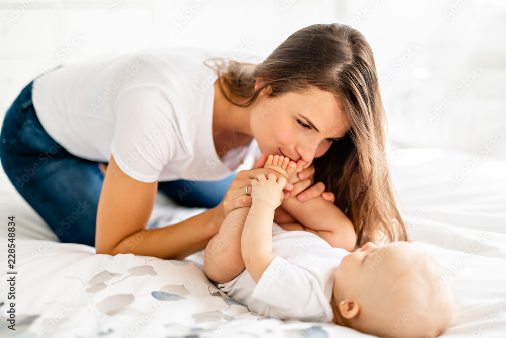 mother with baby on bed having good time mother with baby on bed having good time