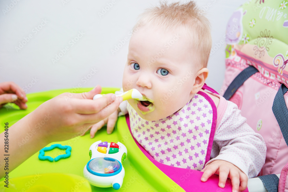 The baby learns to eat from a spoon. The first lure of the baby. The baby learns to eat from a spoon. The first lure of the baby.
