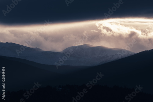 Dramatic winter storm blows over a cold barren landscape at sunset