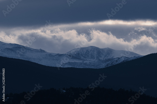 Dramatic winter storm blows over a cold barren landscape at sunset