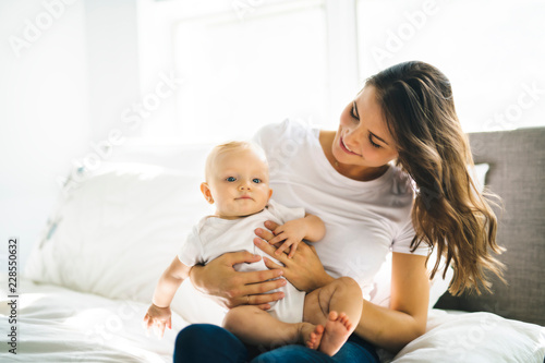 mother with baby on bed having good time